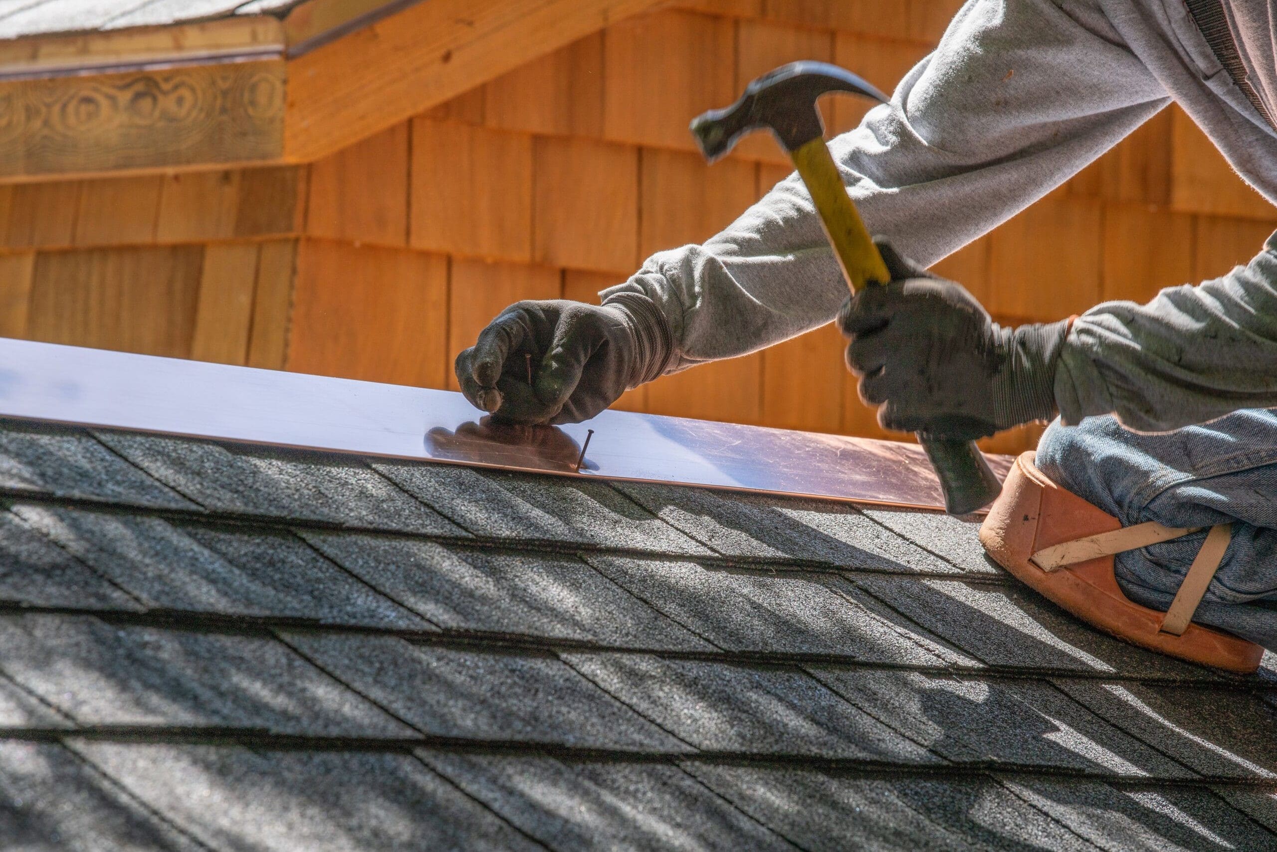 Licensed roofing expert inspecting Campbell property roof with safety gear