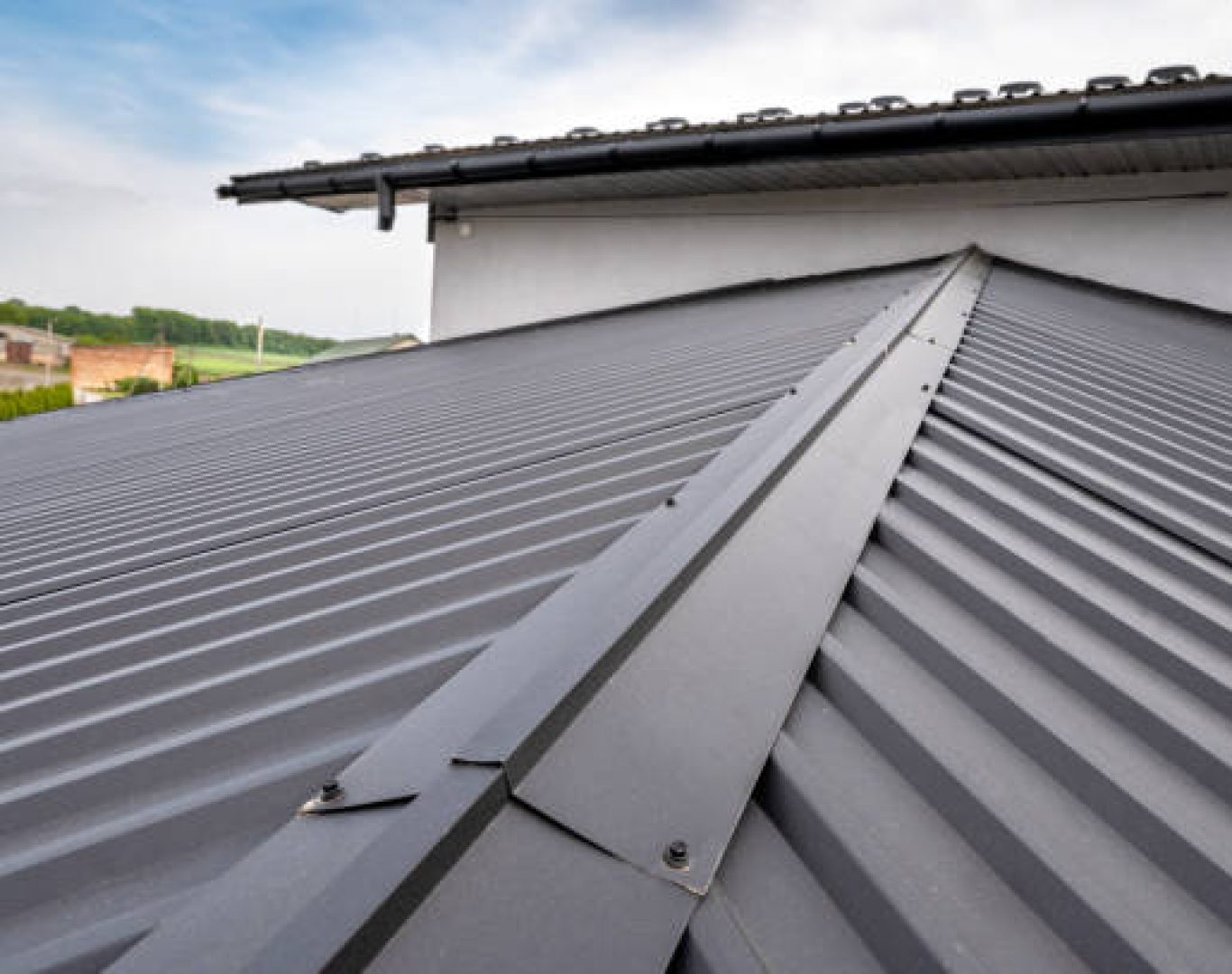 Metal Roofing in Los Gatos, CA being installed as a crew secures panels on a sloped home