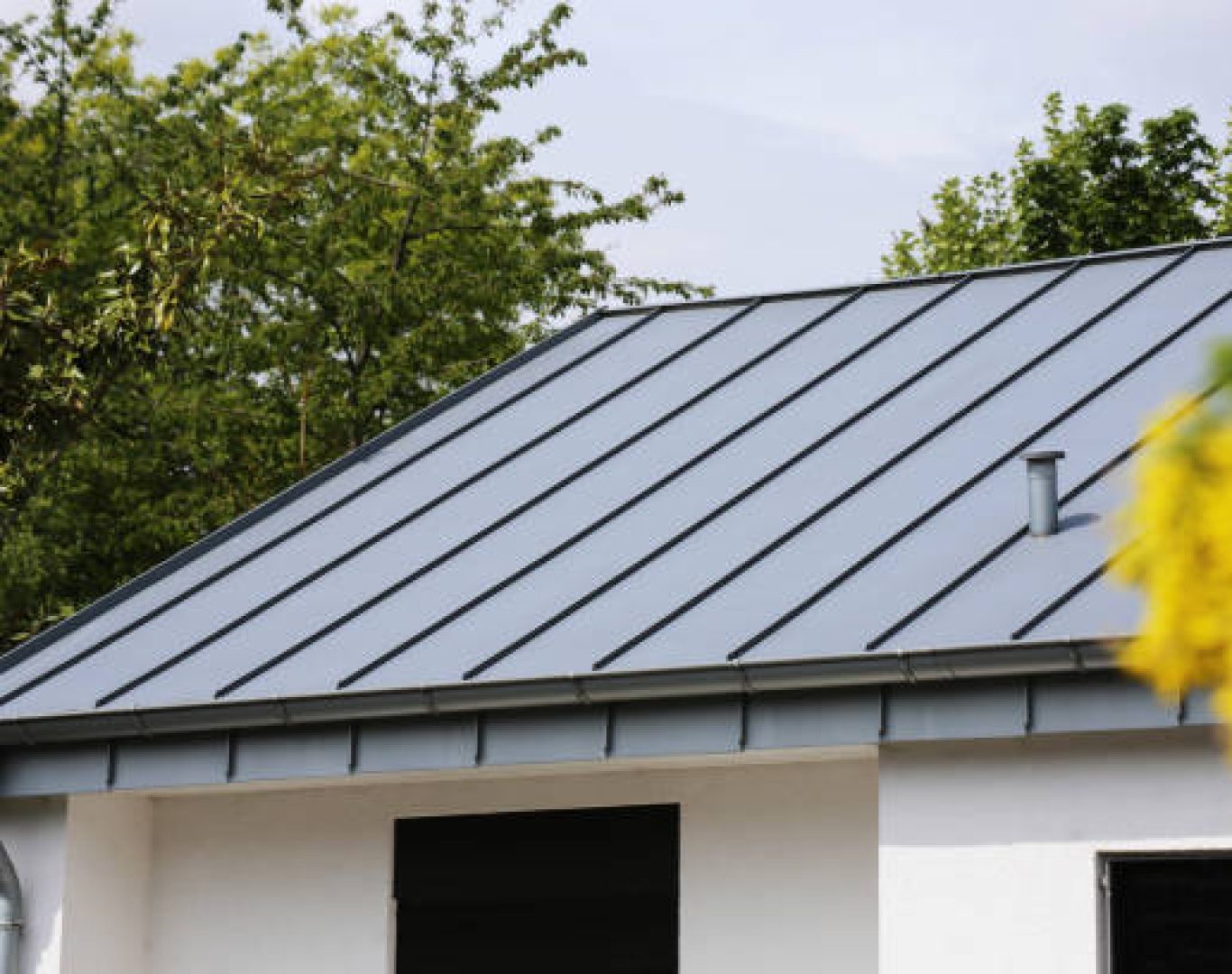 Metal Roofing in Hayward, CA crew fastening panels across a sloped residential roof