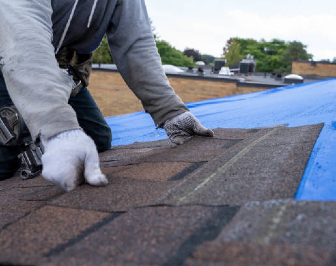 Roof Repair in Los Altos Hills, CA underway as a crew replaces damaged shingles near a chimney